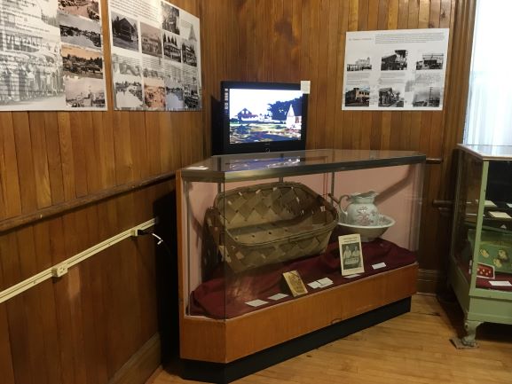 Photo shows a display case with the original basket the Dionne quintuplets were placed in at birth
